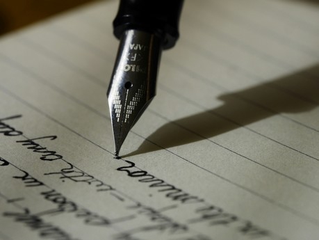 Plume écrivant sur un papier pour l'éditorial de l'académie